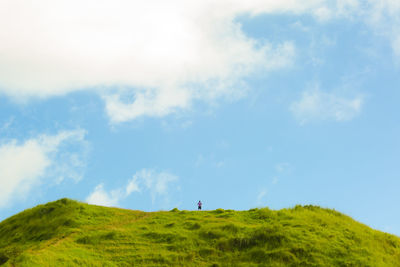 Scenic view of green hill against sky