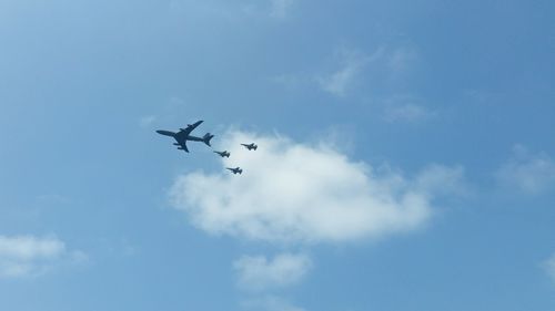 Low angle view of airshow in blue sky