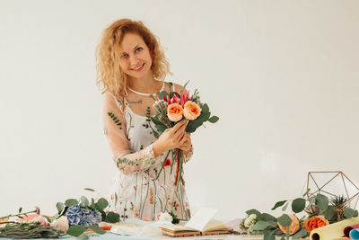 Portrait of woman with roses against white background