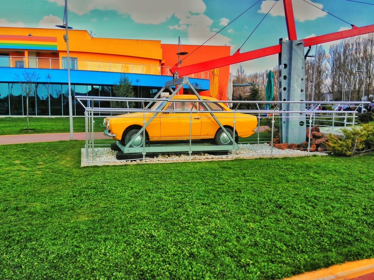 grass, transportation, mode of transport, built structure, architecture, field, yellow, building exterior, green color, sky, grassy, outdoors, day, no people, land vehicle, public transportation, plant, lawn, car, nature