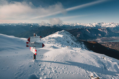 Person on snowcapped mountain against sky