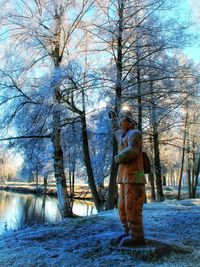 Father and son standing by bare trees against sky