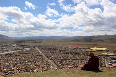 Rear view of woman on landscape against sky