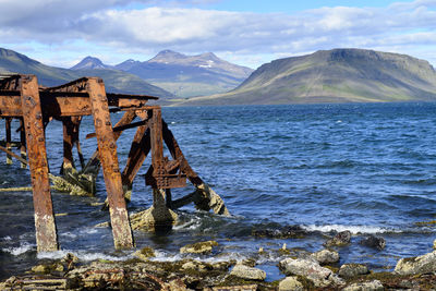 Scenic view of sea and mountains against sky