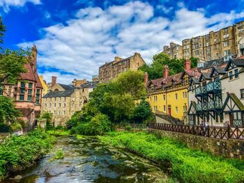 Bridge over river amidst buildings against sky