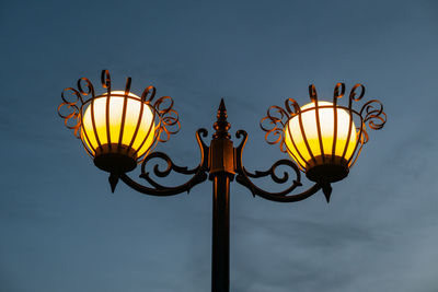 Low angle view of illuminated street light against sky