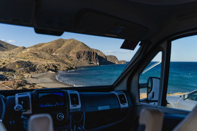 View of sea seen through car windshield