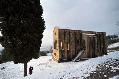 Built structure on snow covered field against sky