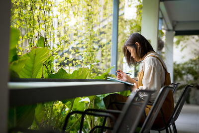 Asian freelance woman use digital tablet for online work from outdoor of office during quarantine