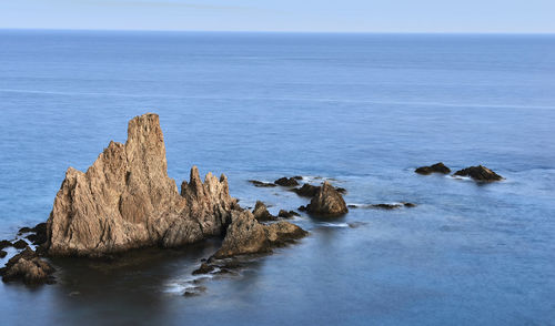 Rocks in sea against sky