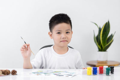 Portrait of cute boy sitting on table