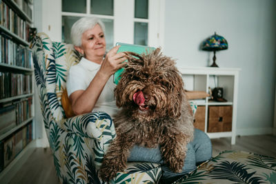 Woman with dog sitting at home