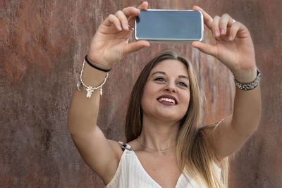 Portrait of woman photographing with mobile phone
