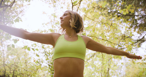 Low angle view of woman standing against tree