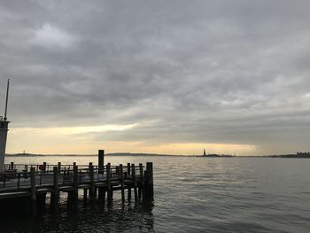 Pier on sea against sky during sunset