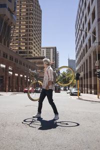 Mature man carrying his bicycle on his shoulders