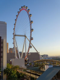 Low angle view of ferris wheel against buildings