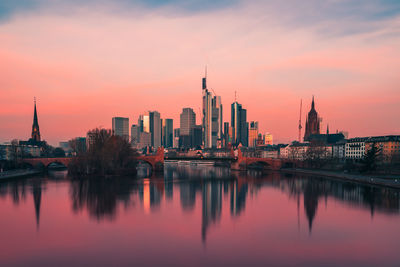 Reflection of buildings in city at sunset