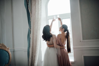 Side view of two women standing in corridor