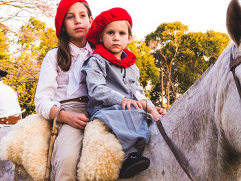 Siblings sitting on horse