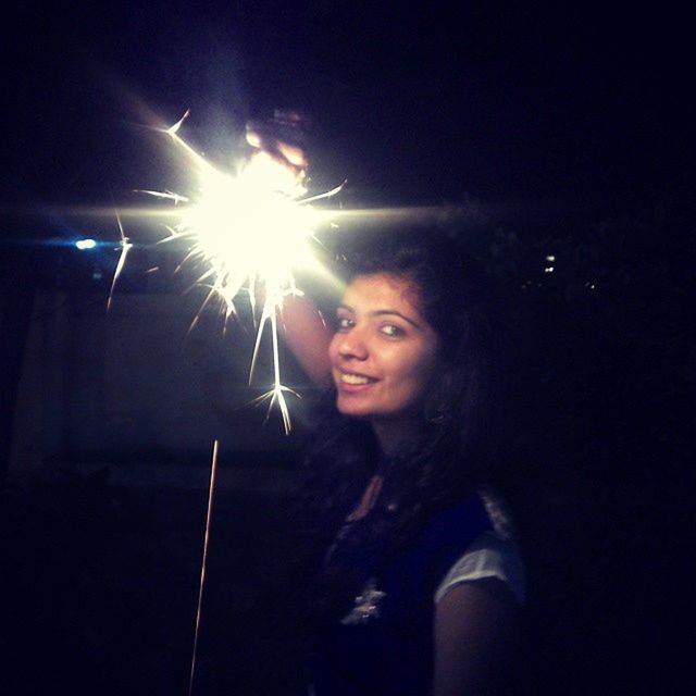 night, illuminated, lifestyles, leisure activity, glowing, arts culture and entertainment, fire - natural phenomenon, celebration, burning, event, young adult, sparkler, young women, light - natural phenomenon, holding, flame, firework - man made object, front view