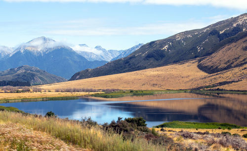 Scenic view of lake and mountains against sky