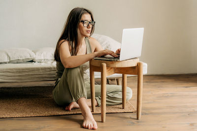 Young happy woman is using laptop and headphones for online education.