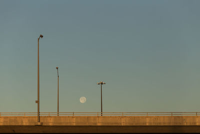 Low angle view of street lights on elevated road against sky