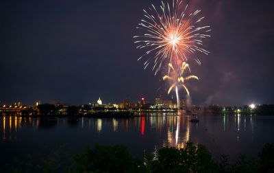 Firework display over river at night