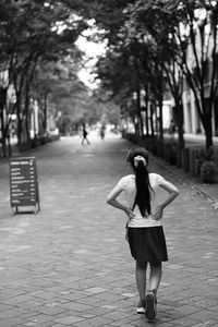 Rear view of woman walking on street in city