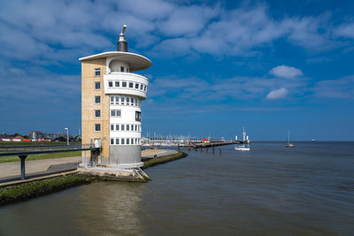 View of lighthouse by sea against sky