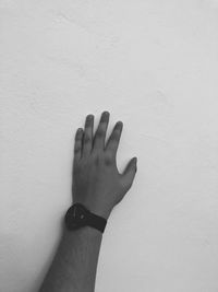Close-up of hand against white wall
