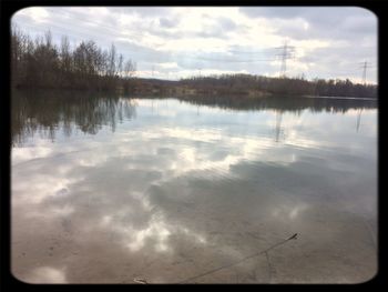 Scenic view of lake against cloudy sky