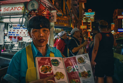 Portrait of people standing in market at night