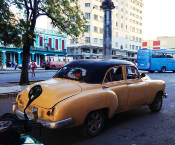 Car on street against buildings in city