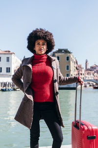 Young black woman holding luggage travel bag