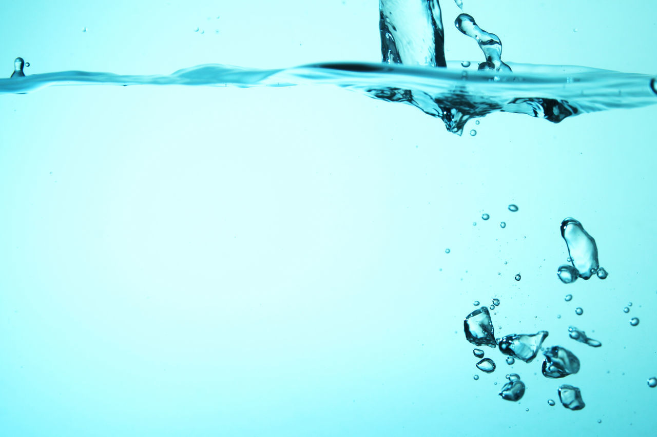 CLOSE-UP OF WATER DROP AGAINST BLUE BACKGROUND