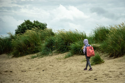 Rear view of woman walking on beach