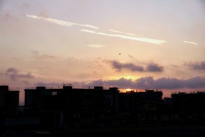 Silhouette buildings against sky during sunset