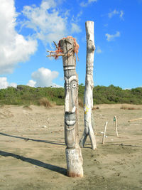 Tree on wooden post on field against sky