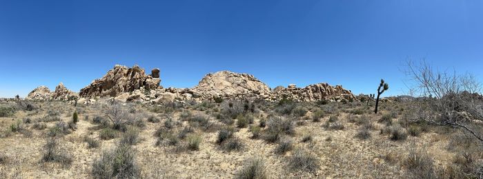 Low angle view of rock formations against clear blue sky
