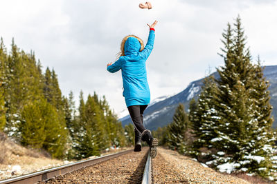 Full length rear view of woman walking against sky