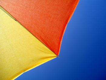 Low angle view of flag against clear blue sky