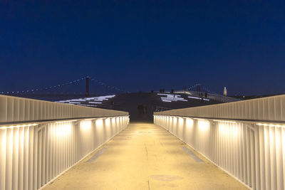 Illuminated bridge against clear blue sky at night