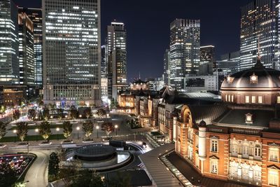 High angle view of illuminated street amidst buildings in city at night