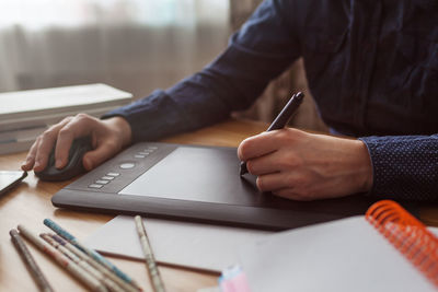 Midsection of man using laptop on table