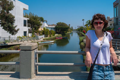 Young woman posing for camera with venice beach canal in the background