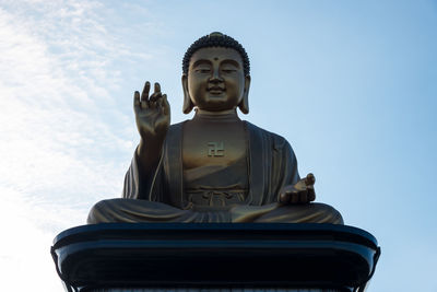 Low angle view of buddha statue against clear sky