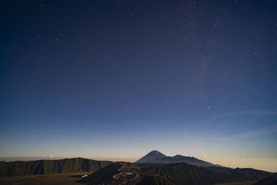 Scenic view of snowcapped mountains against sky at night