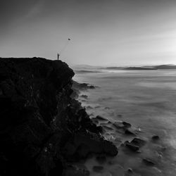 Rock formation on beach against sky
